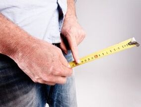un hombre mide la longitud del pene antes del aumento con refresco